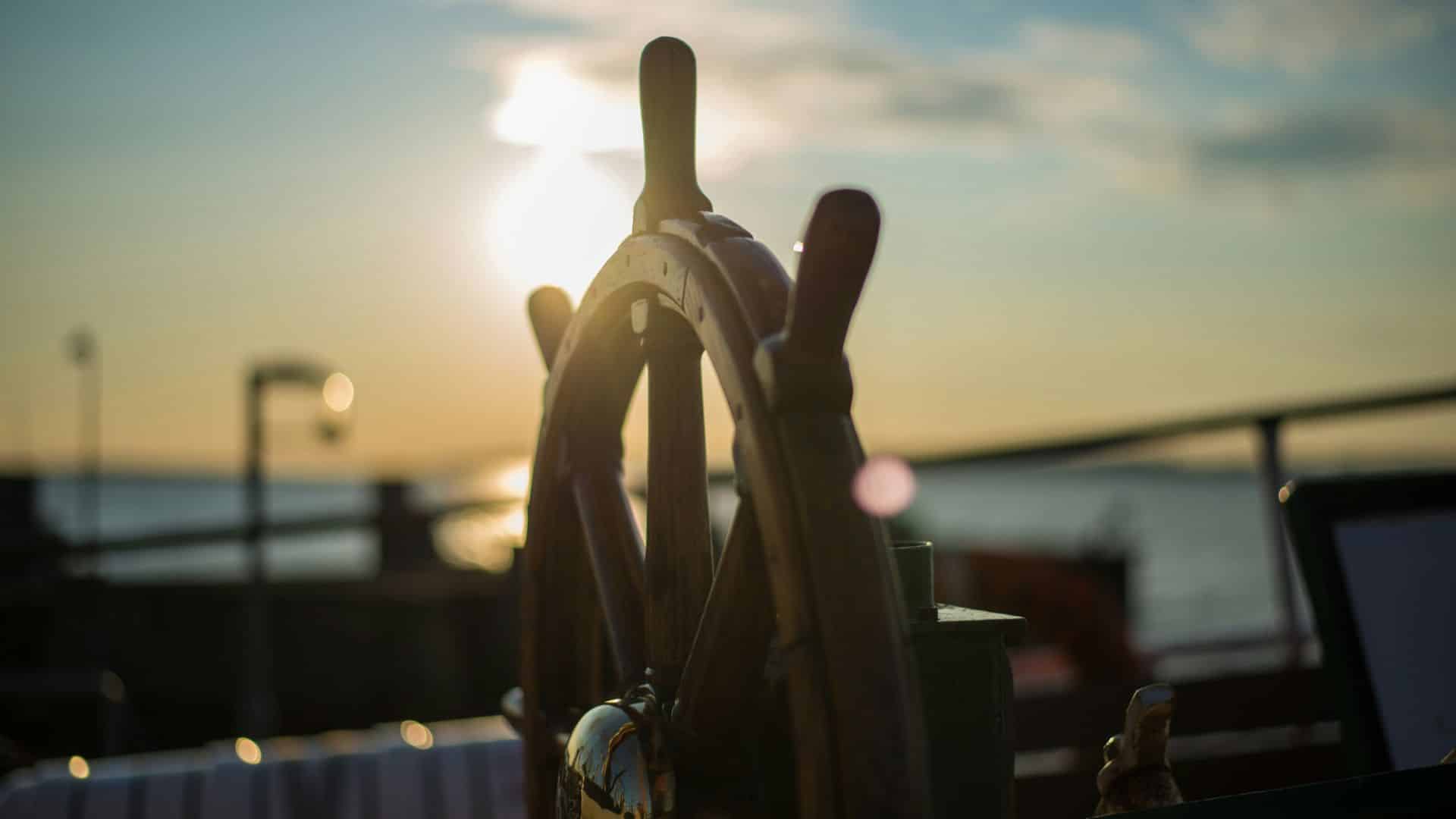 Steuerrad mit Sonnenuntergang im Hintergrund