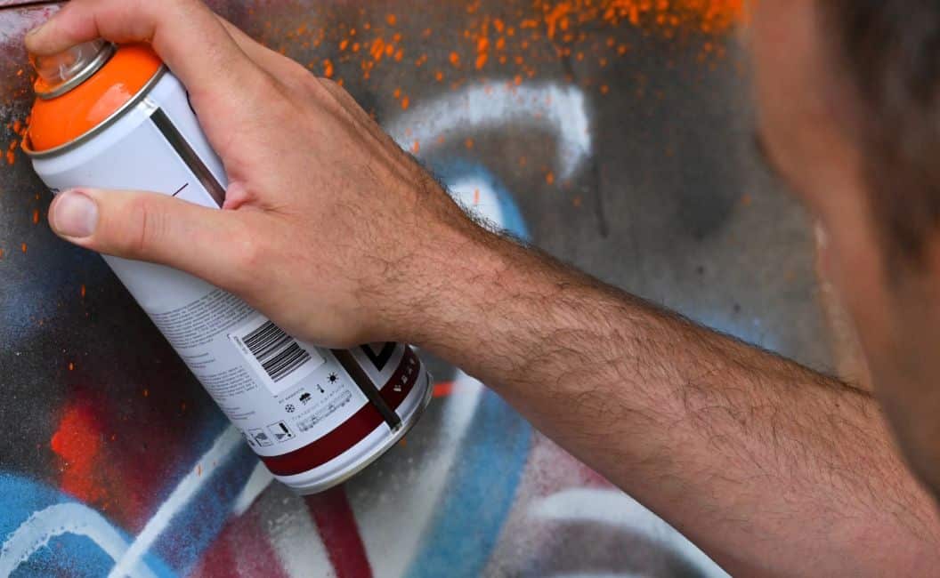 Mann sprüht eine Wand an